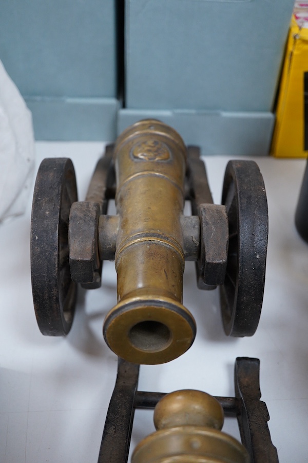 A pair of brass and cast iron model cannons, 34cm in length